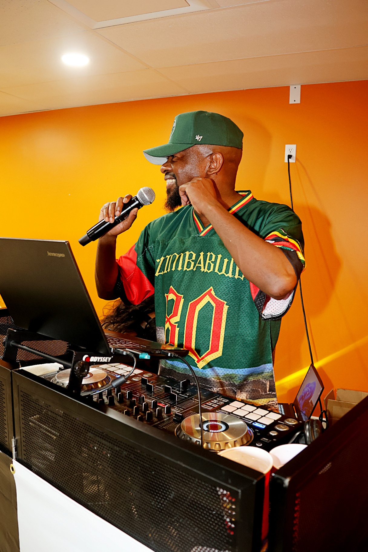 DJ in Zimbabwe jersey on the mic at ZimConnect 2026 ArtSphere